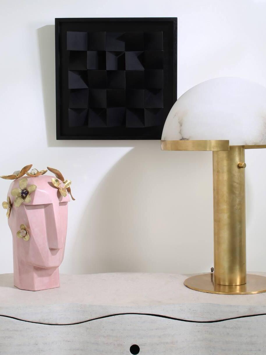 Gold dome lamp beside flowers and wall art