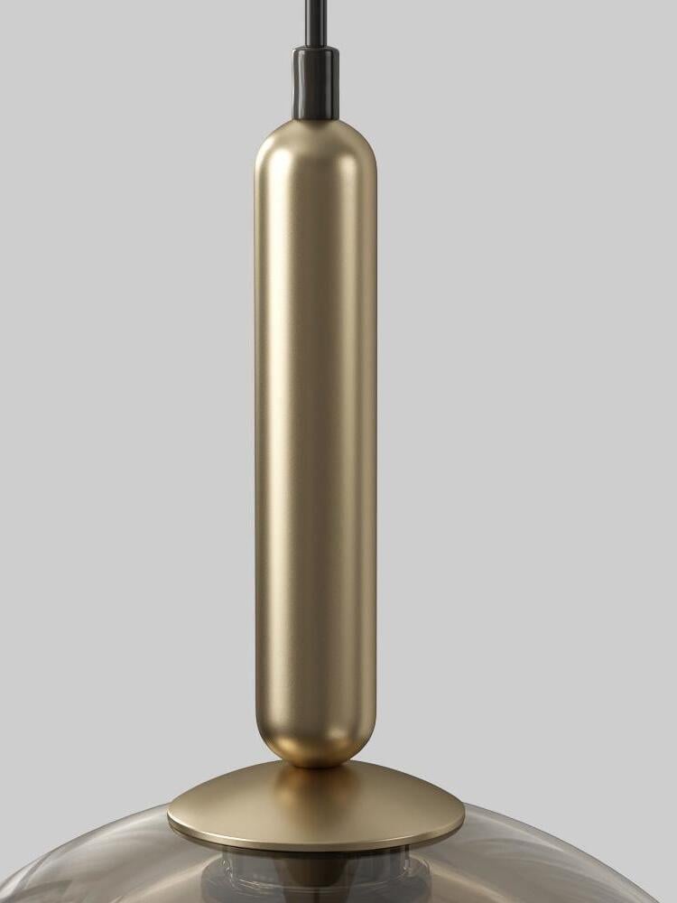 Detail of elongated gold-tone upper fitting and round cap above the glass dome, with black cable entry
