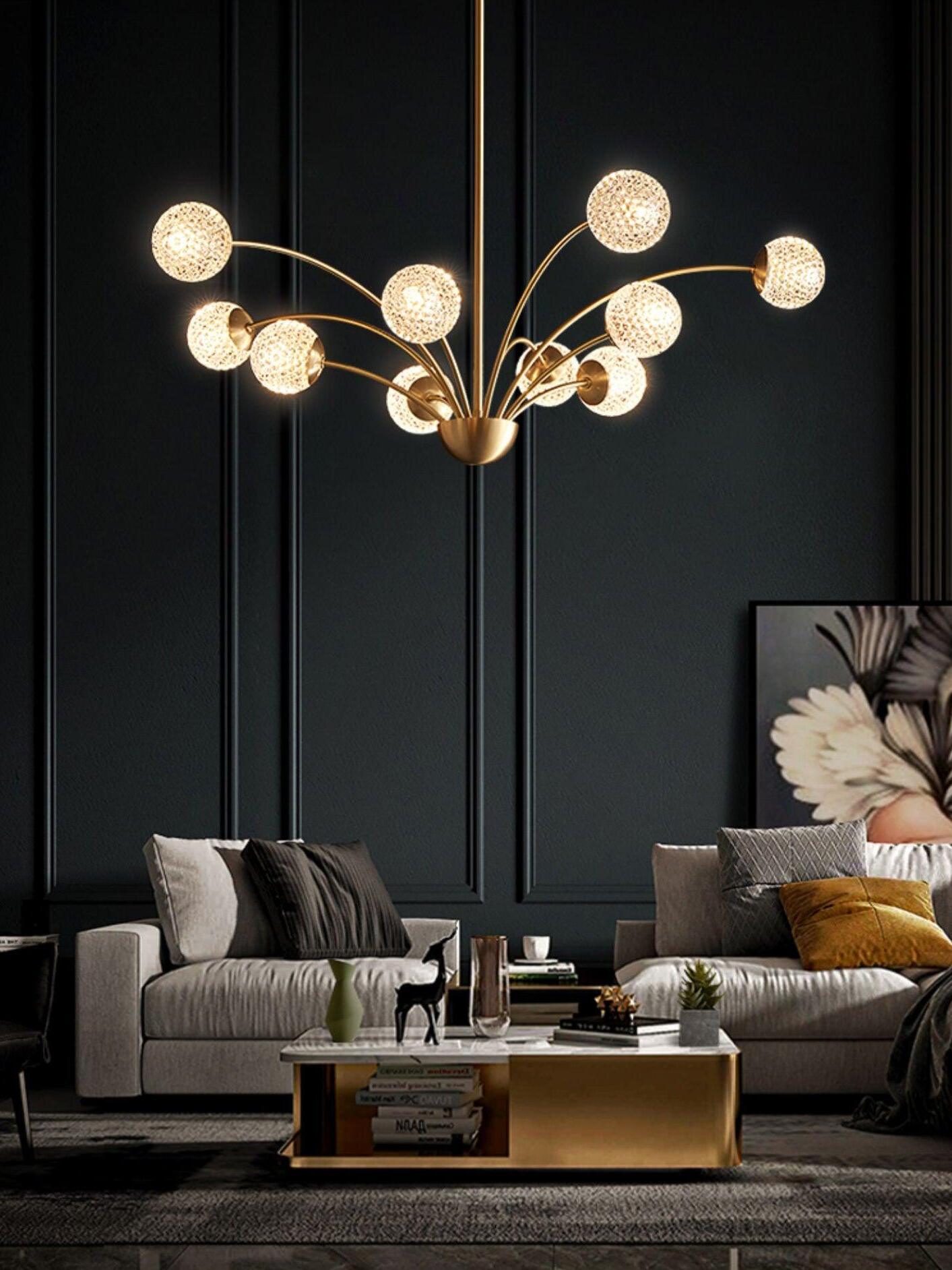 Textured globe chandelier above an armchair and sofa with a gold-tone coffee table and floral artwork