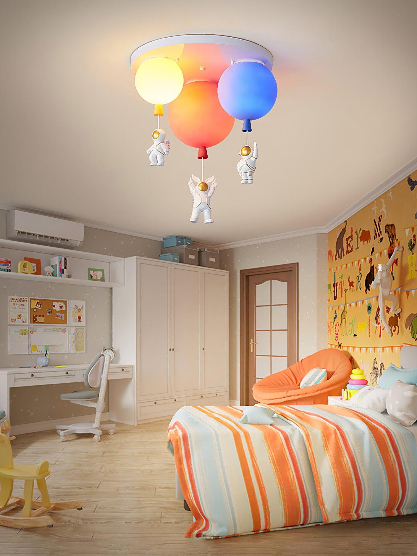 Coloured balloon ceiling light over orange-striped bedding