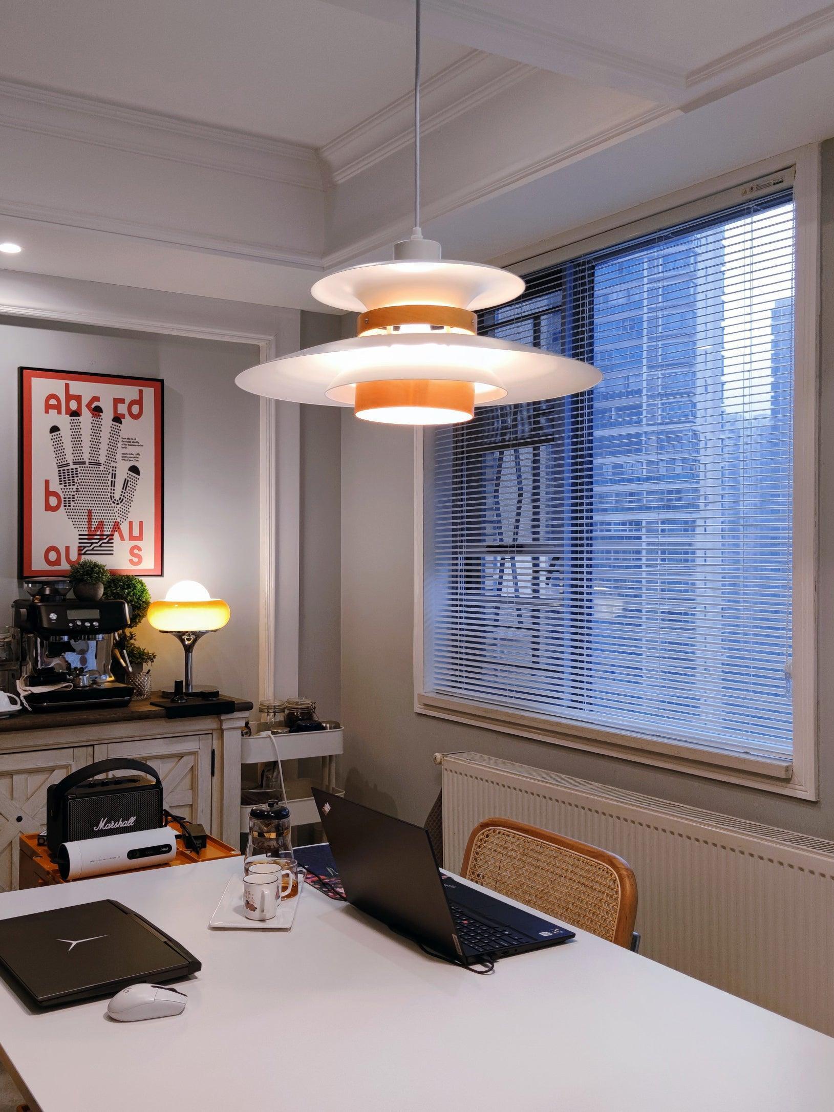 Layered pendant above a dining table near a window