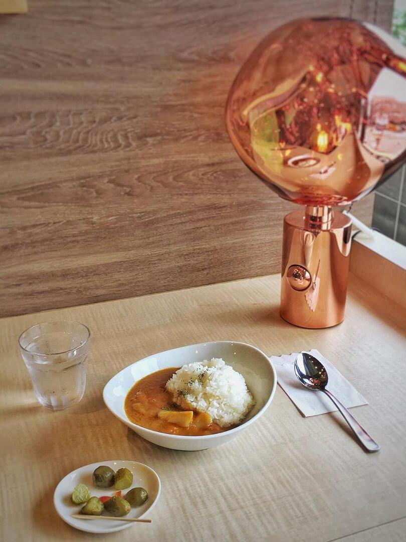 Red-toned Melt table lamp beside a dining place setting