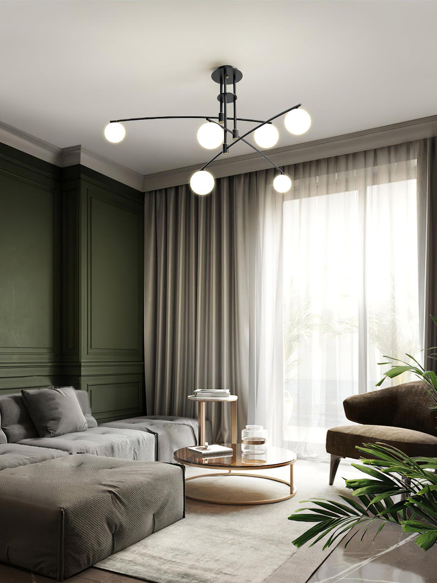 Black branching chandelier beside living-room curtains