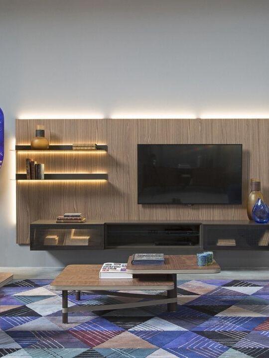 TV wall and shelving with table and rug, narrow blue lamp panel cropped at left edge