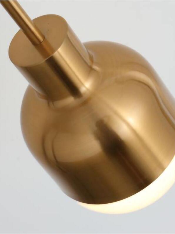 Angled close-up of Niku gold-tone upper housing and neck with the illuminated white lower shade