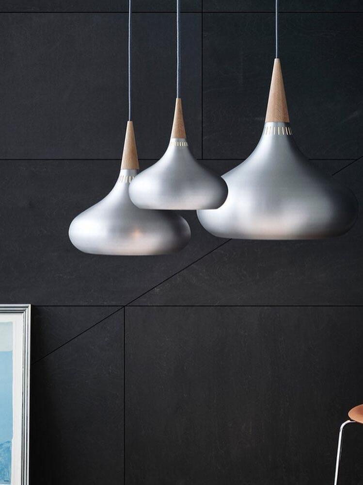 Three silver-toned pendants with tapered wooden necks