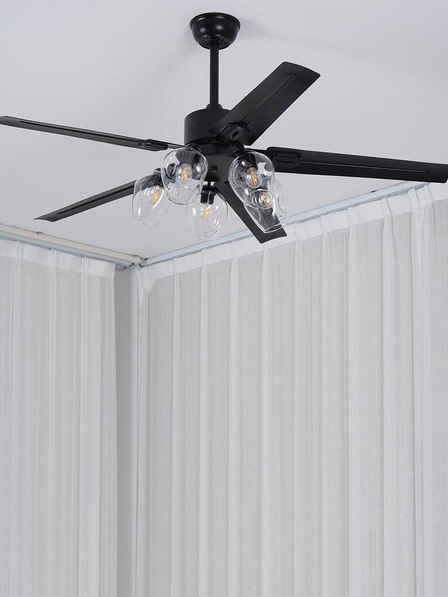 Black fan with open rounded glass shades beside curtains