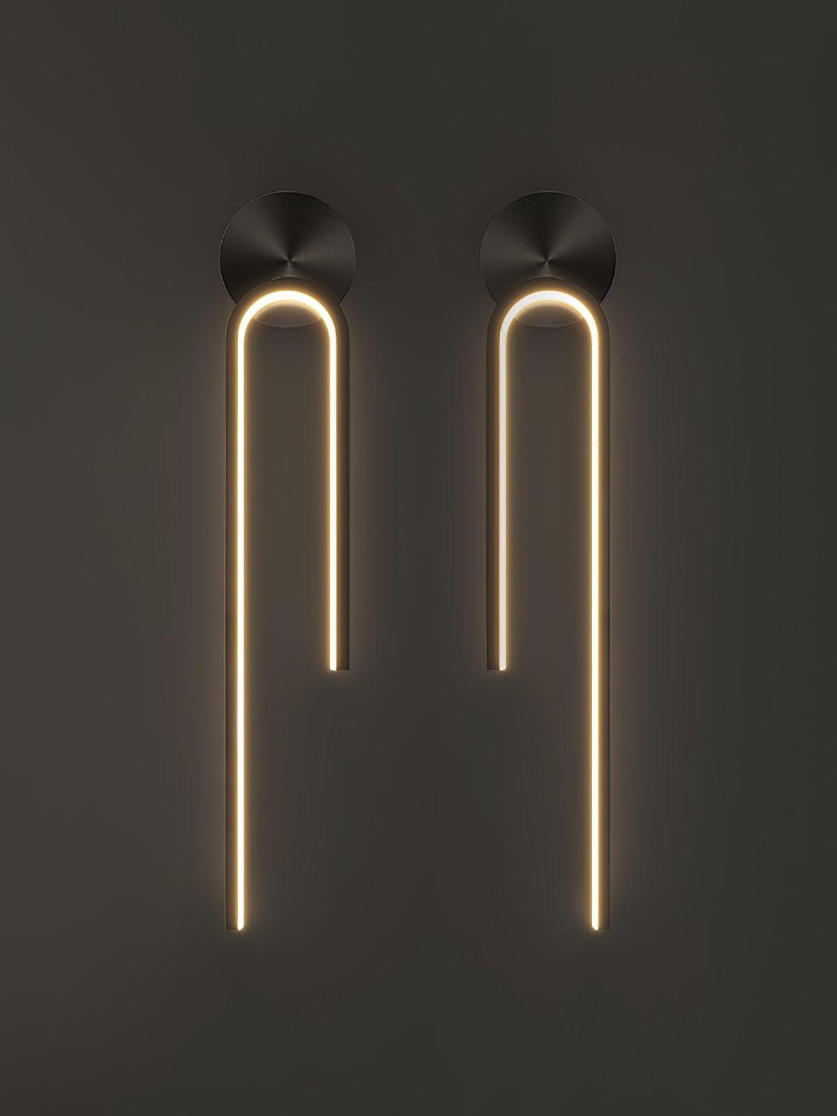 Two glowing black arch wall lights with mirrored long outer arms and round backplates on dark gray