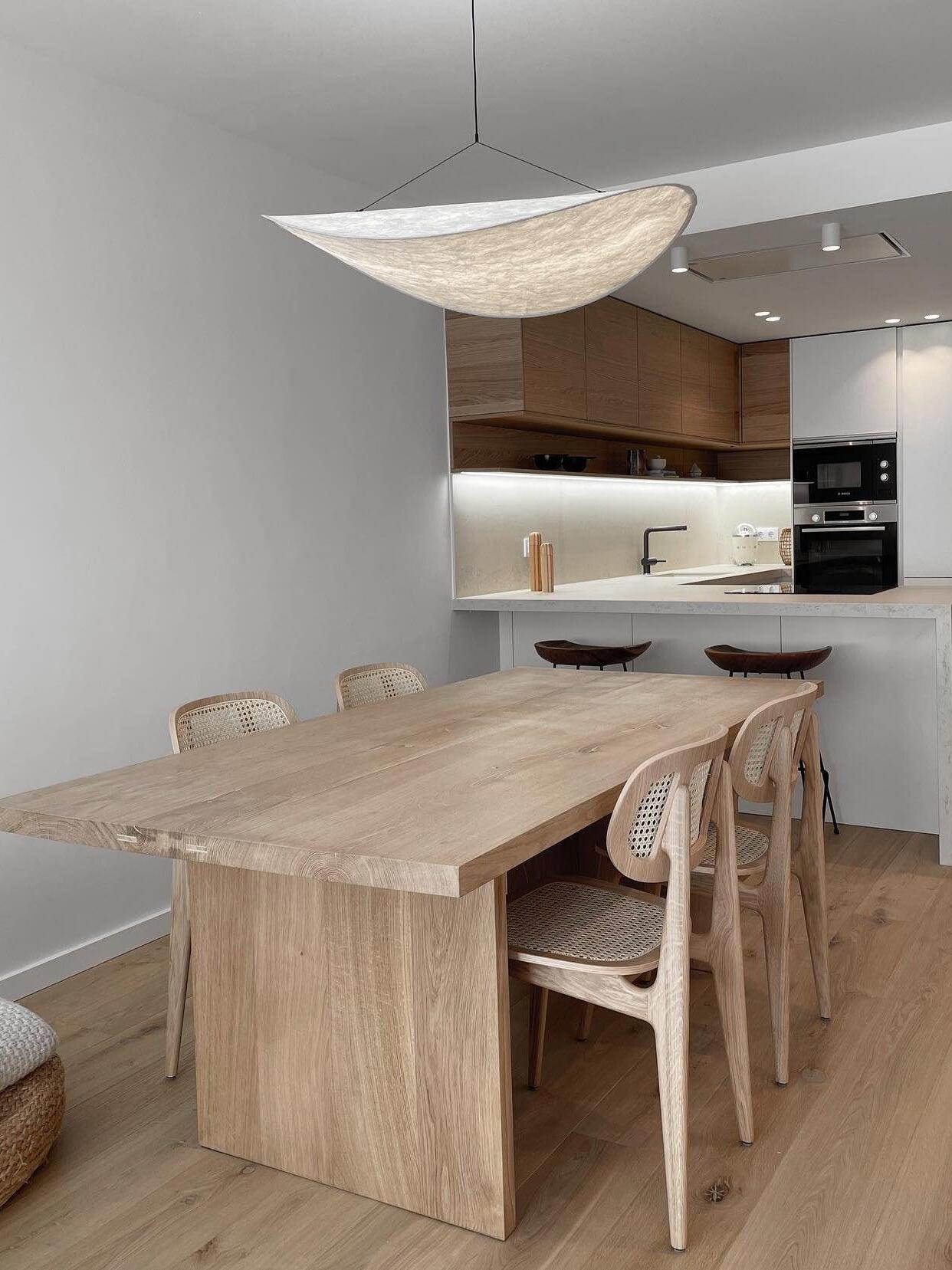 Curved textured pendant over a wood dining table