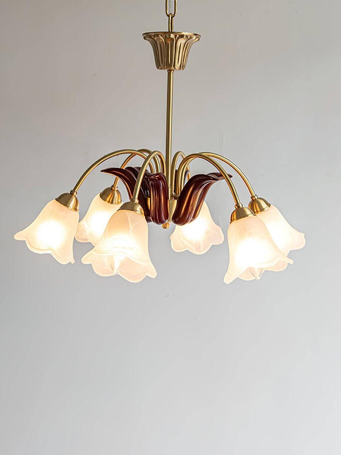 Curved brass arms and white flower shades, angled view