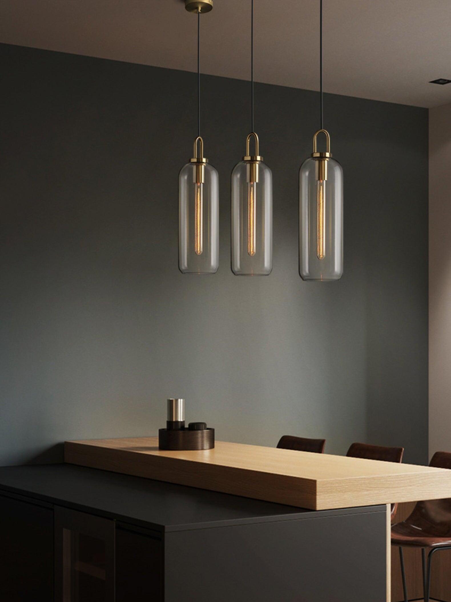 Clear capsule pendant group above a dark kitchen counter
