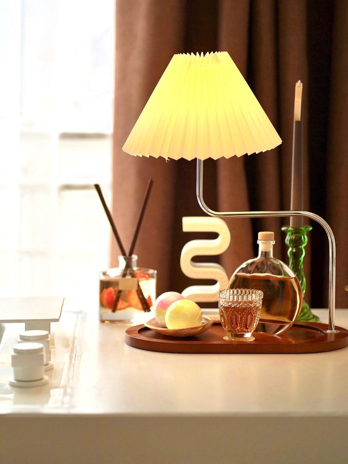 Lighted pleated shade on tray beside glassware
