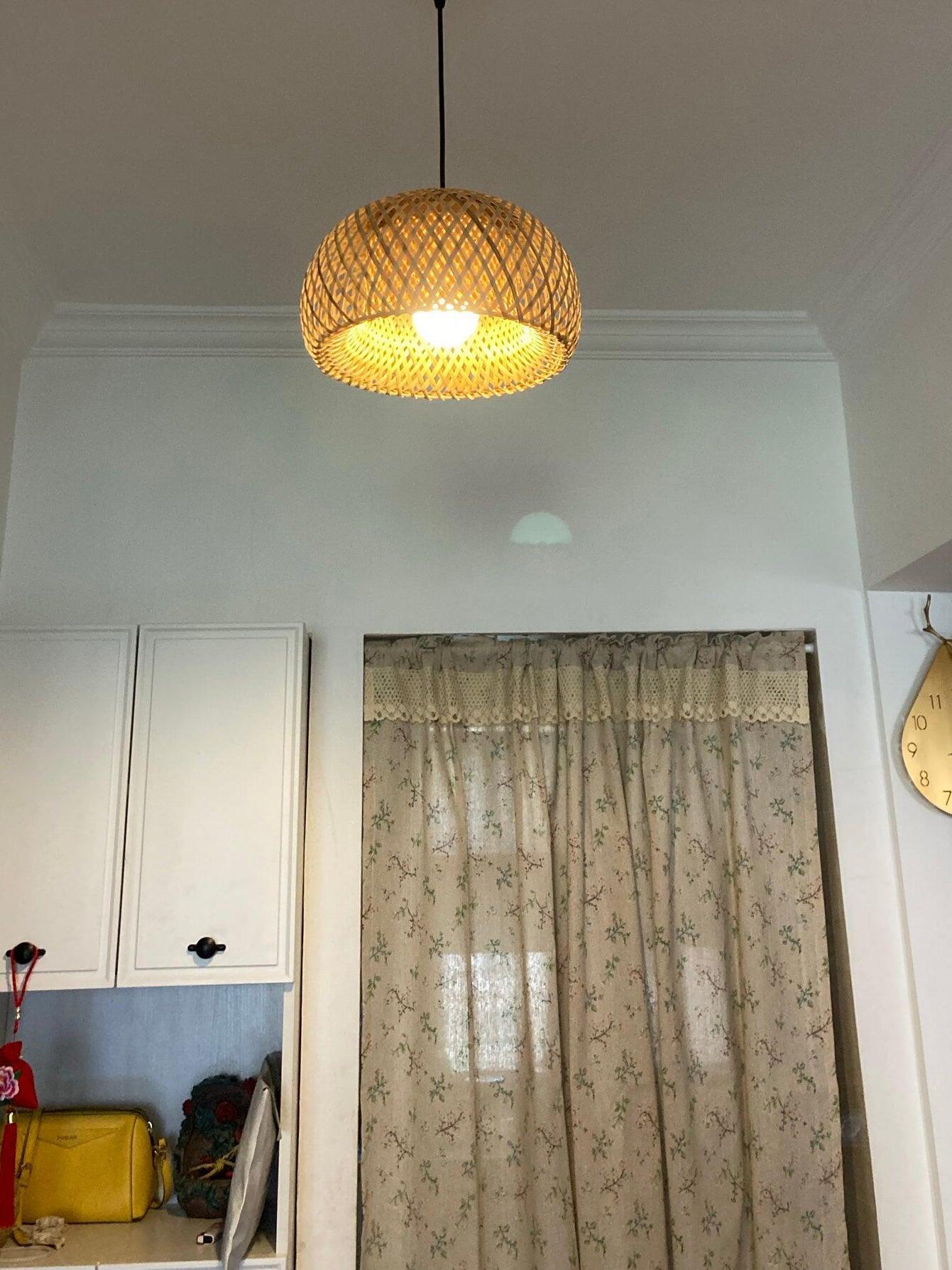 Glowing basket shade in room with pale curtains