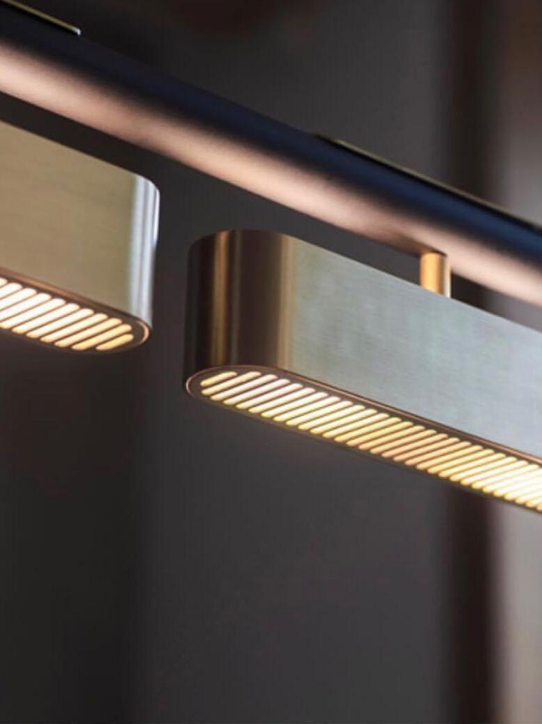 Underside close-up of illuminated parallel slots in Colt brass modules beneath a black rail