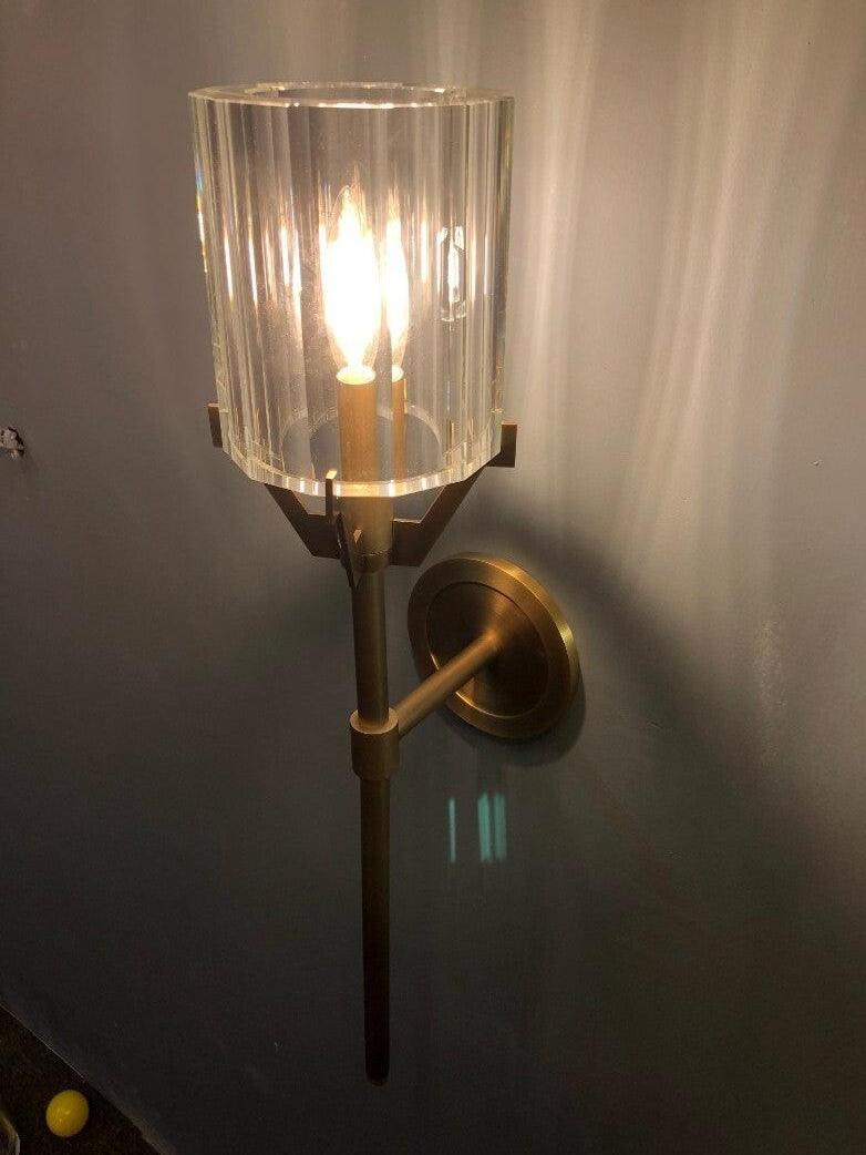 Angled view of an illuminated Gold glass sconce