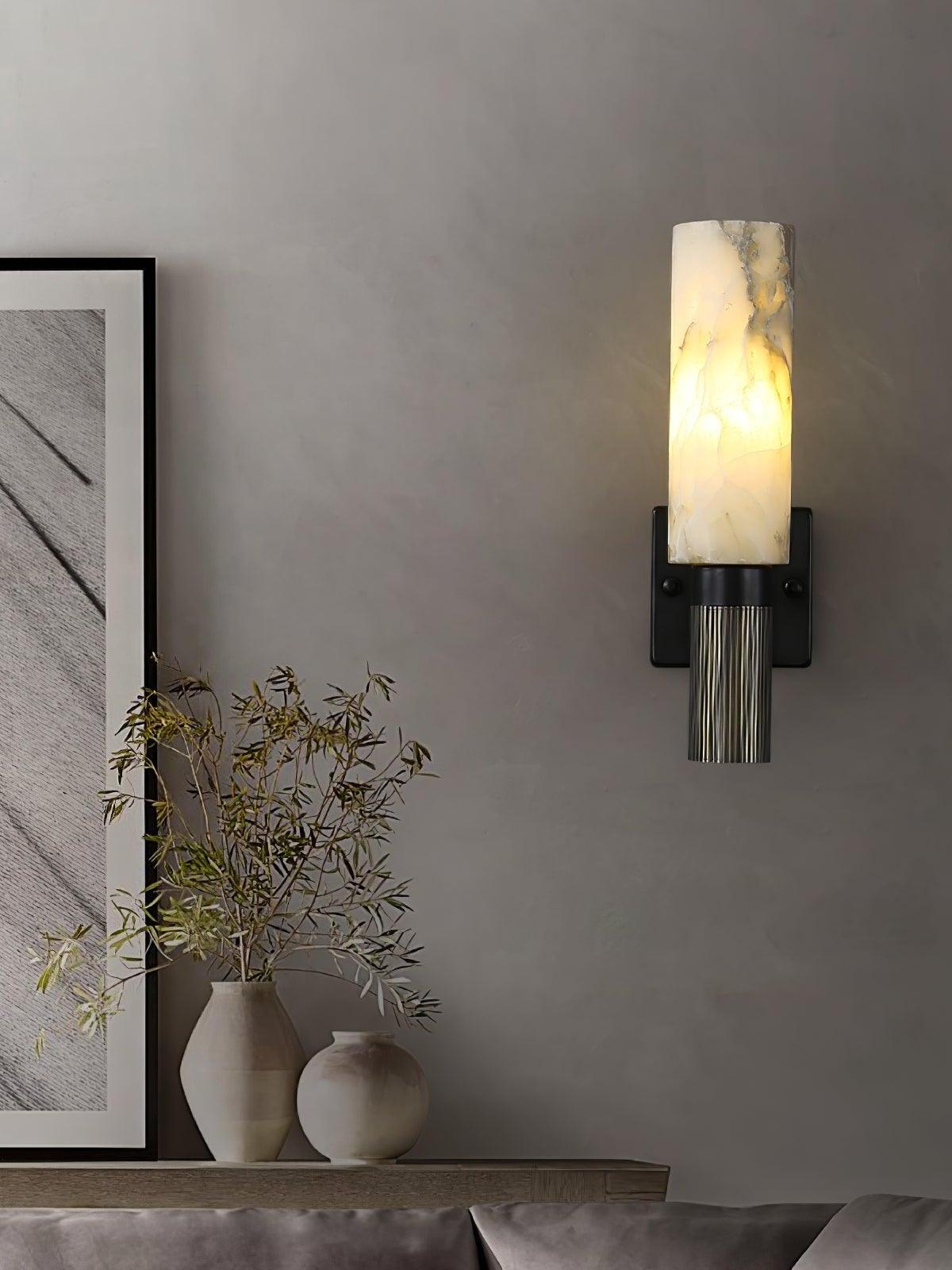 Marble wall sconce above low console and framed art