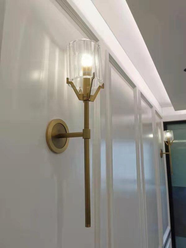 Clear-glass Gold wall light along an indoor wall