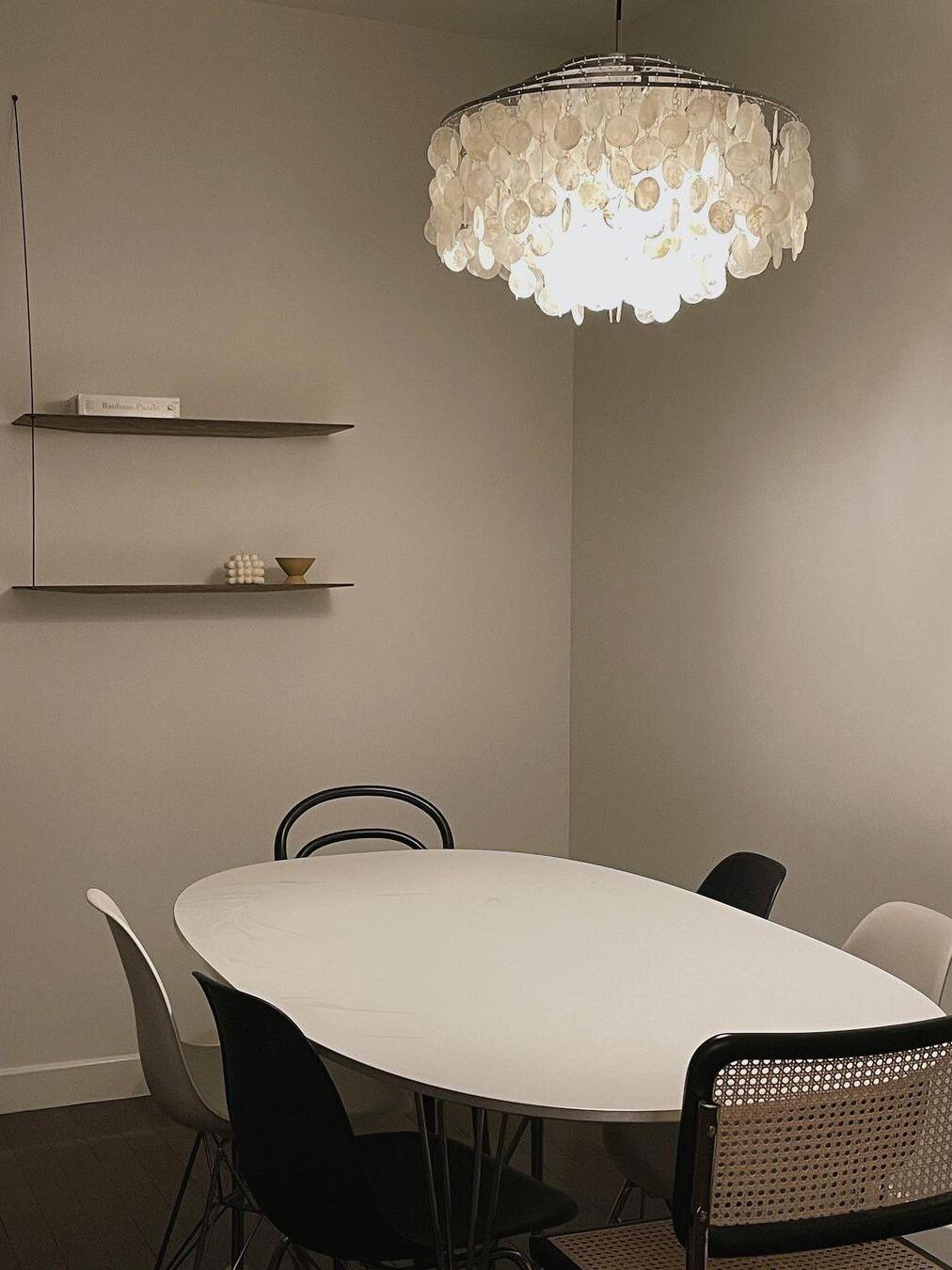 White shell discs above a pale dining table