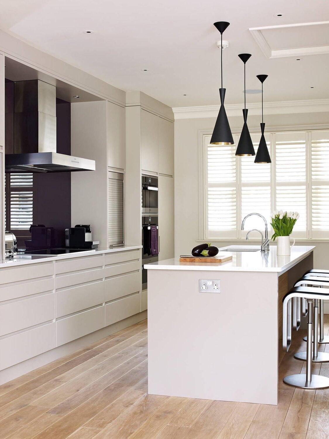 Tall black cone pendants above a kitchen island