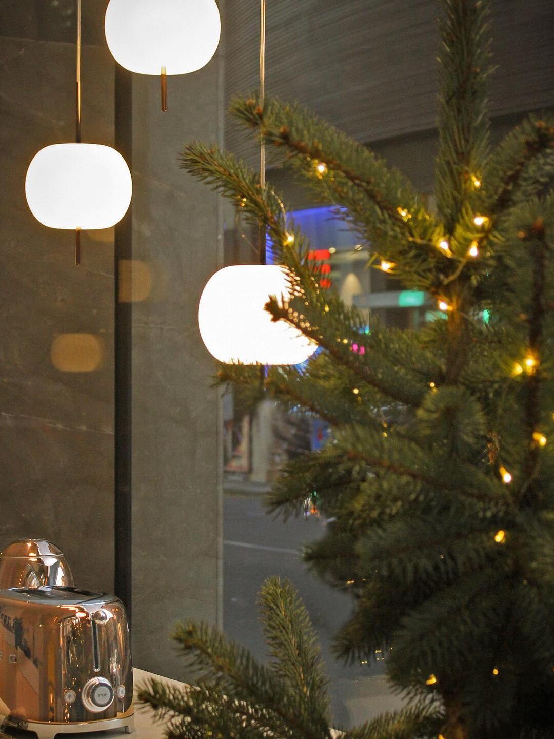 Rounded white pendants beside a decorated tree