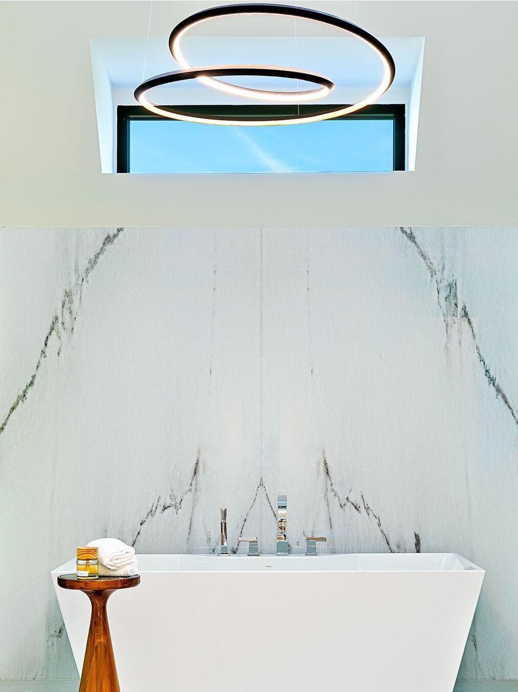 Bathroom setting with a black looping chandelier above a bathtub