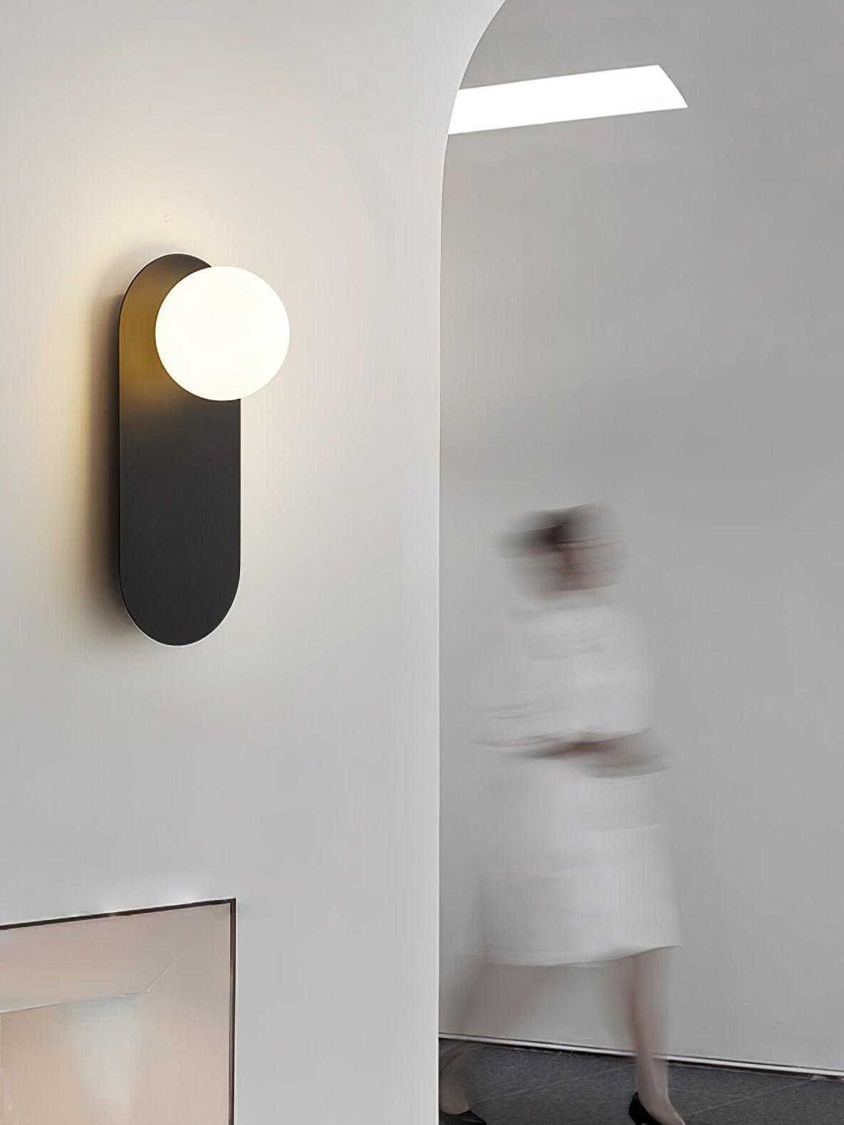 Black globe sconce beside an arched doorway