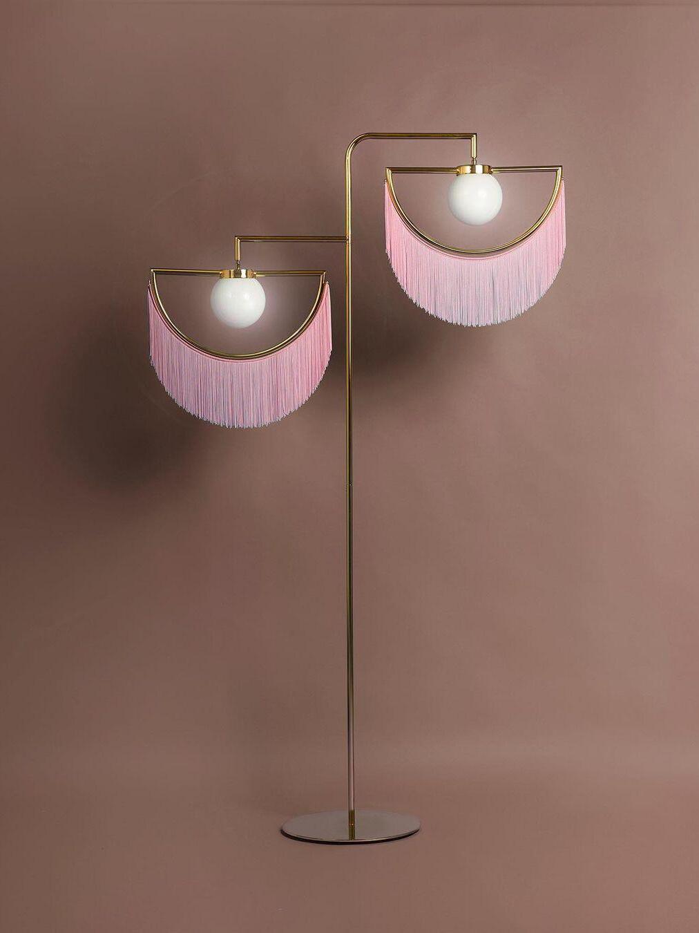 Wink pale pink fringe floor lamp against a brown wall