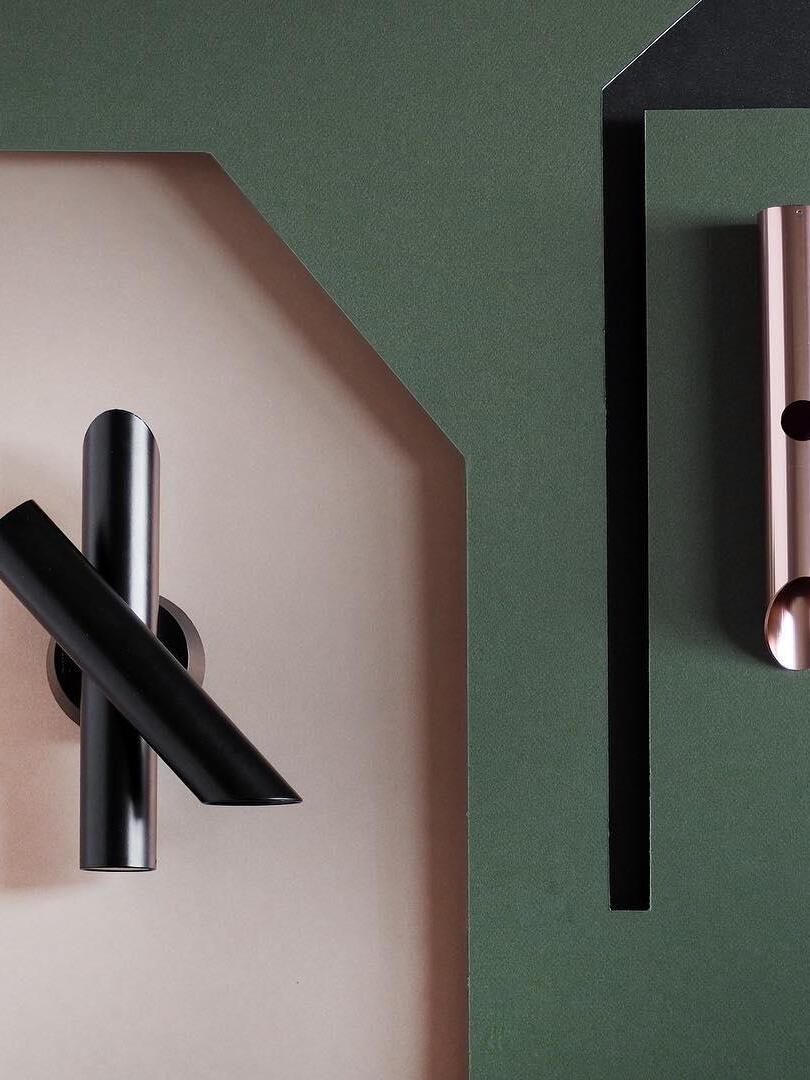 Black crossed-tube wall light in two-tone interior