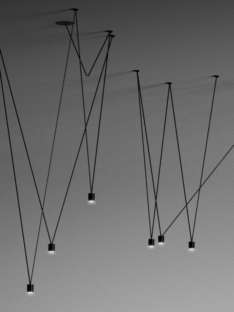 Six glowing black cylindrical terminals at varied heights in a crossing suspension arrangement