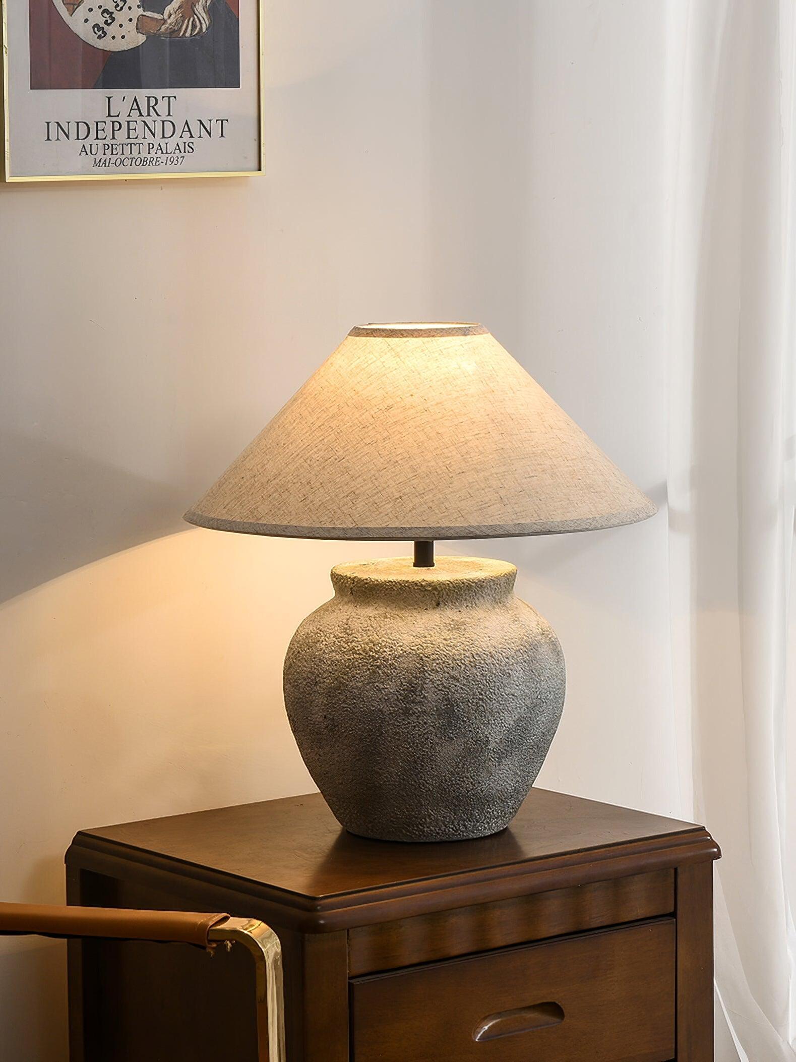 Weathered urn lamp on wooden bedside cabinet