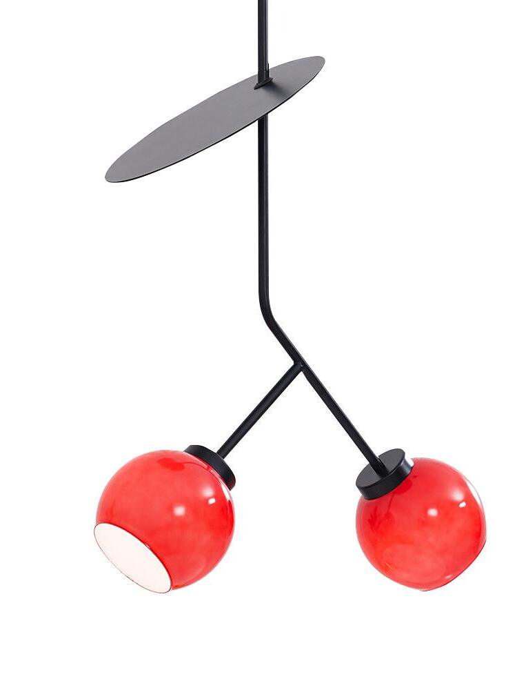 Two illuminated red glass shades on black forked stems below an angled oval disc