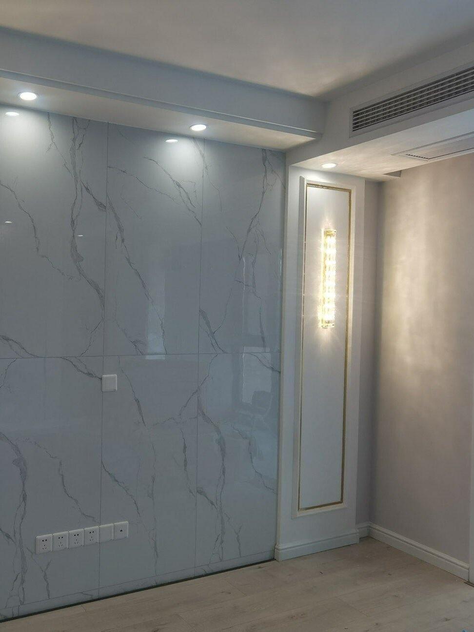 Room view with glass wall light beside pale veined panels
