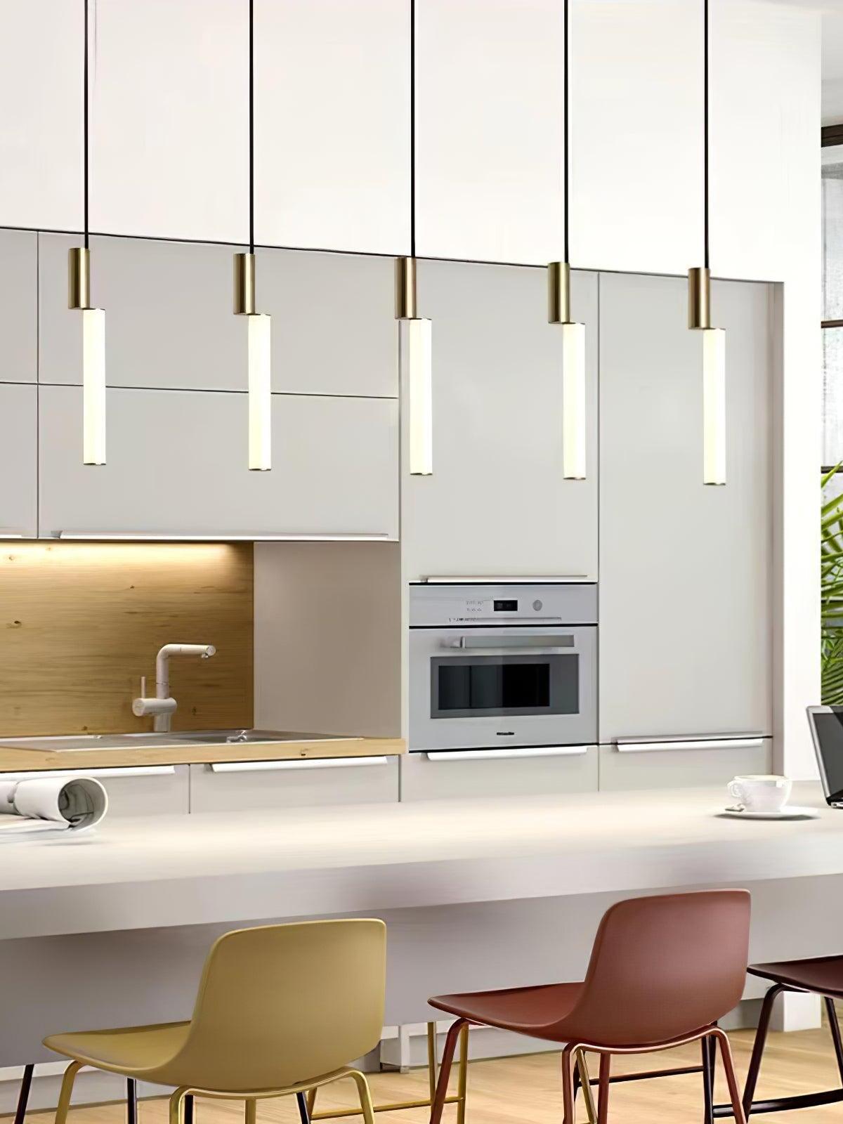 Five gold-top tube pendants above kitchen island