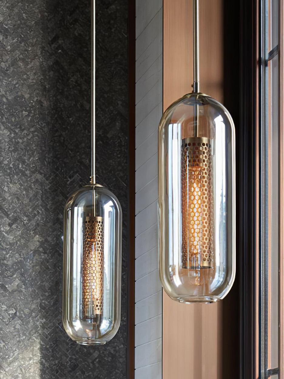 Two clear capsule-shaped shades with perforated inner cylinders beside dark stone and vertical wall panels