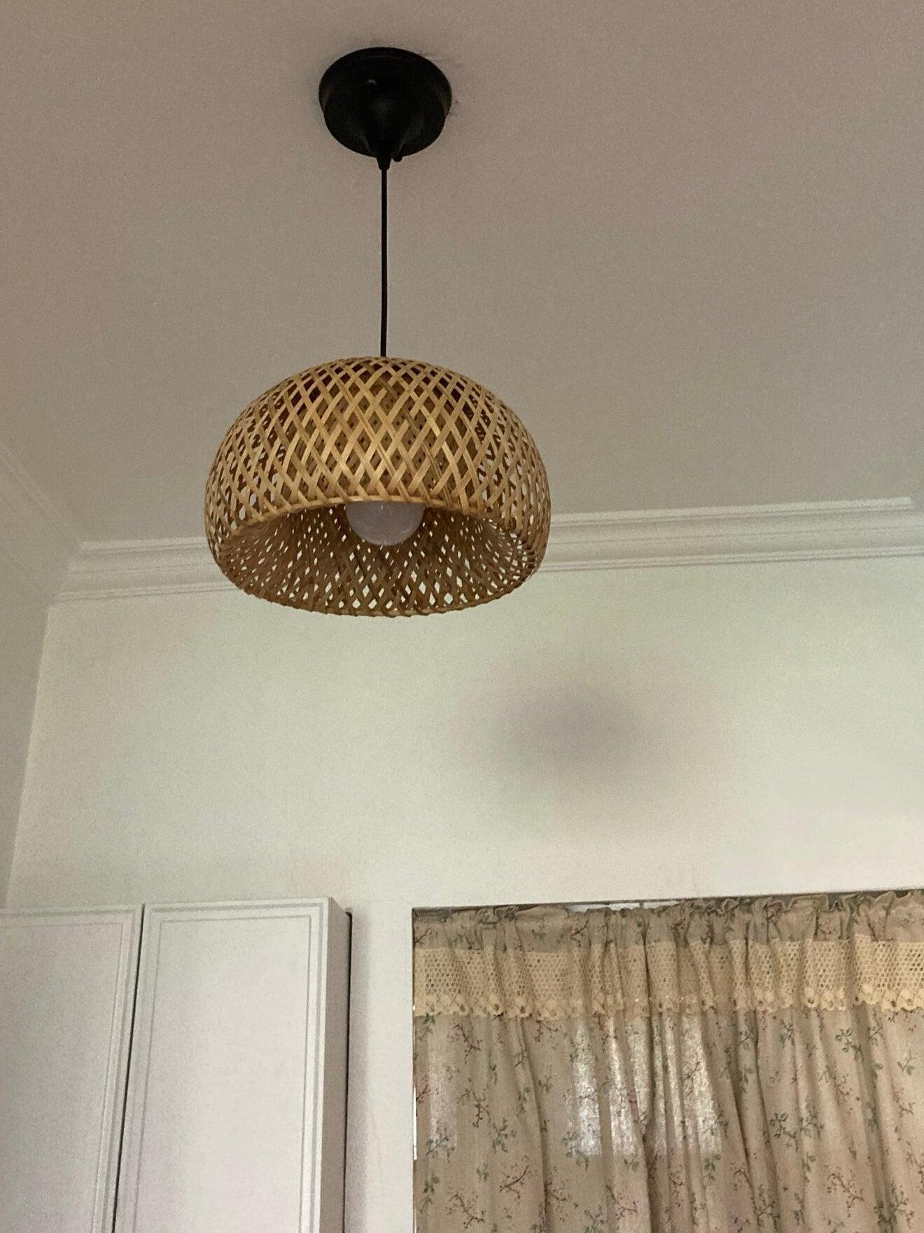 Close woven bamboo shade with bulb visible underneath