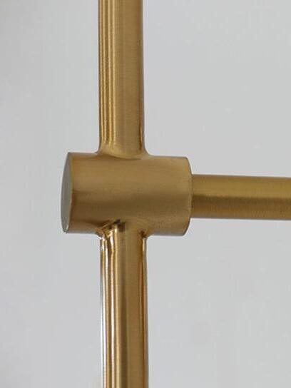 Close-up of the gold-tone cylindrical joint connecting the vertical rod and short horizontal wall arm