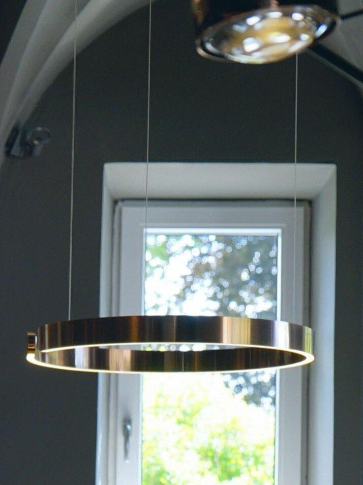 Metallic ring pendant in front of a window