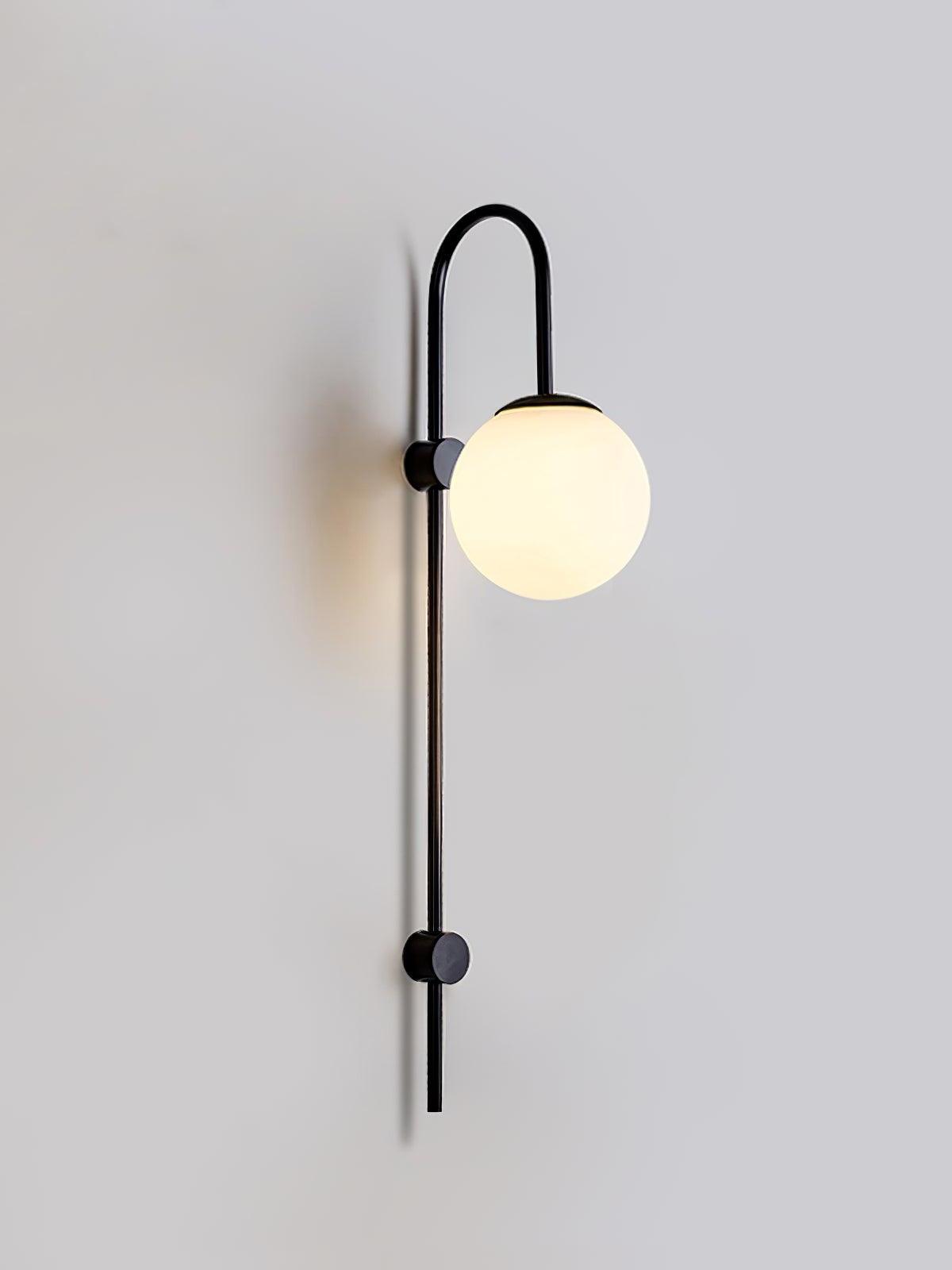 Black curved wall sconce with lit white glass globe