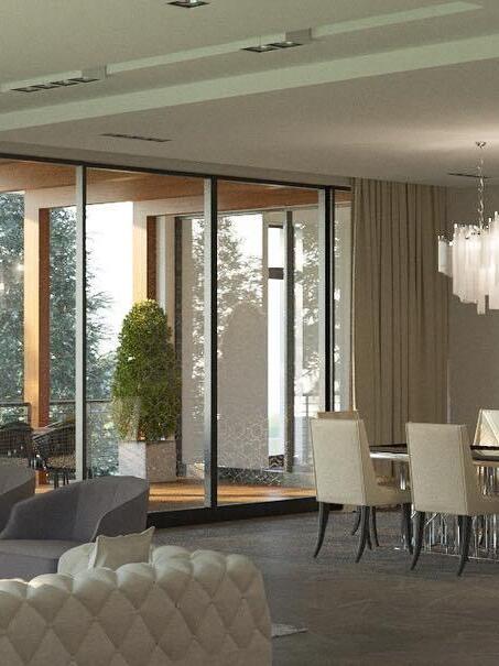 Part of a chain chandelier at the edge of a tall-windowed living and dining room