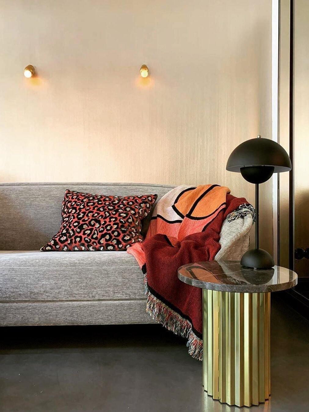 Pair of small wall fixtures above a sofa in a living room