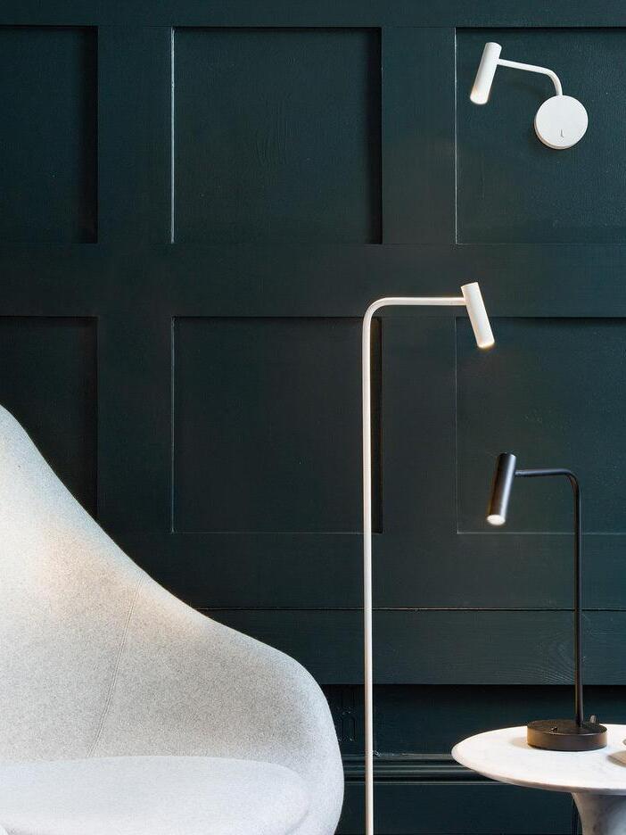 White wall reading sconce shown with other reading lamps