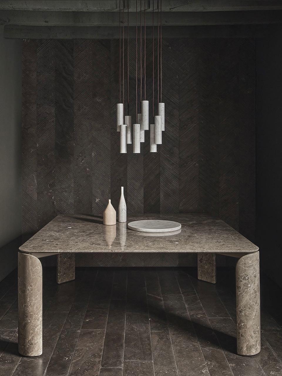 A small unlit Silo cluster above a stone table with a vase and plate in a dark room