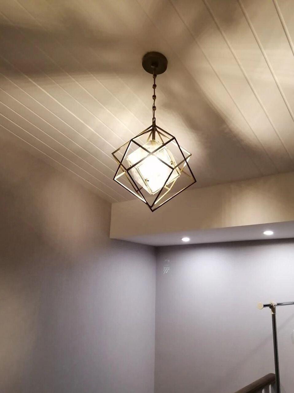 Illuminated Epic pendant below a paneled ceiling with light patterns visible around it