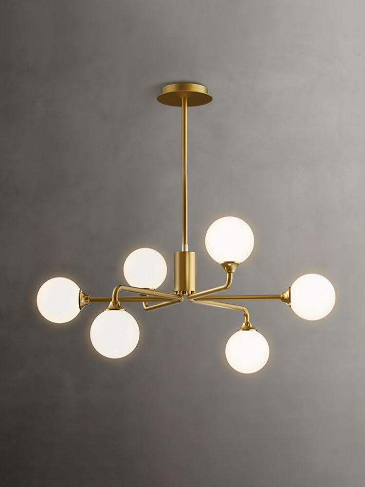 Six-globe brass chandelier against grey wall