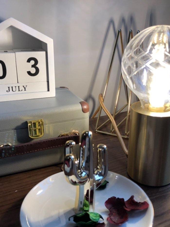 Cropped glowing glass-globe lamp beside clock and decorative figures