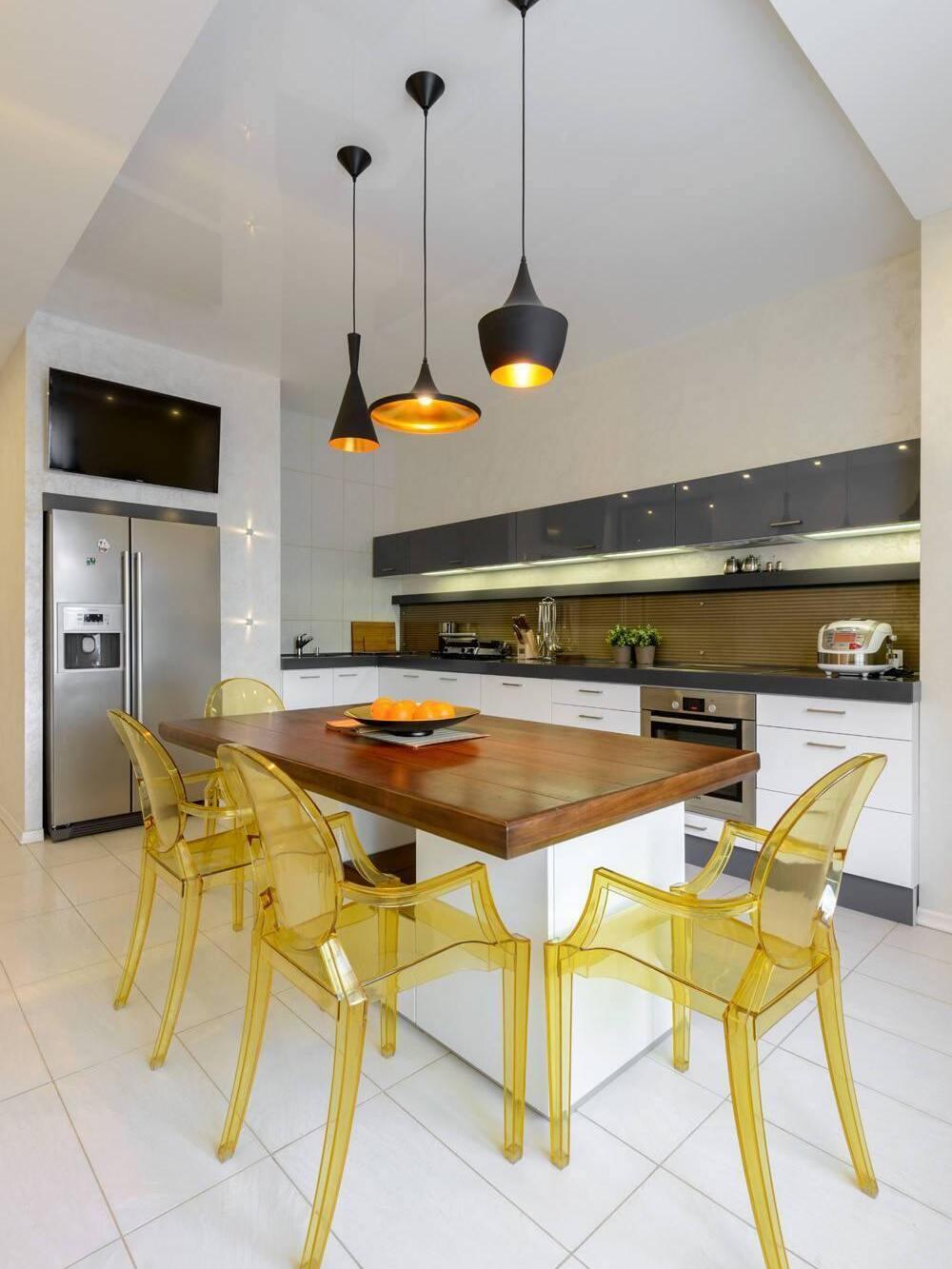 Black pendant shapes above a counter with yellow stools