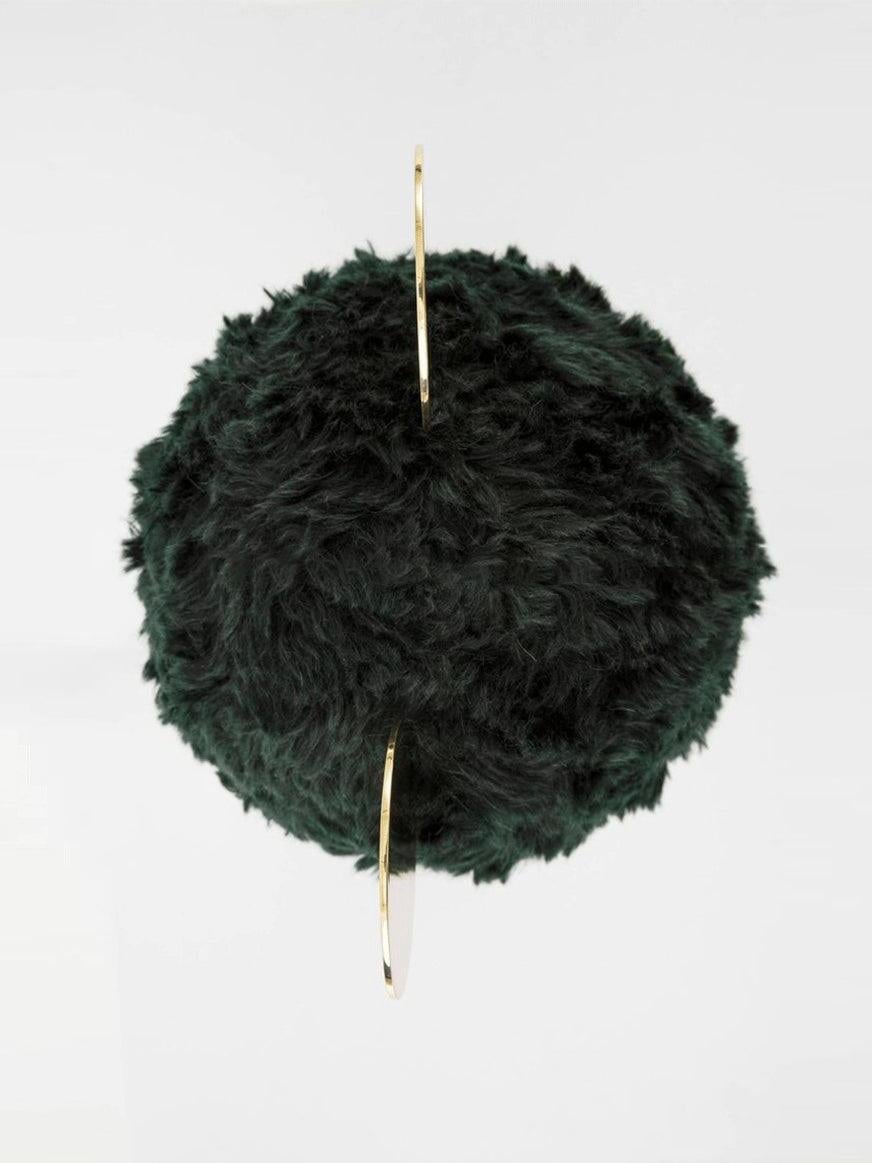 Top view of dark green plush shade with gold-tone round accents seen edge-on