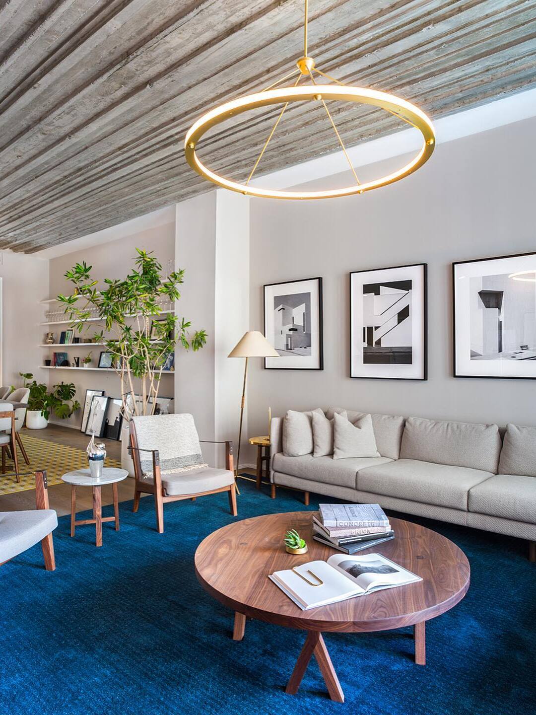 Gold circular pendant below slatted living-room ceiling