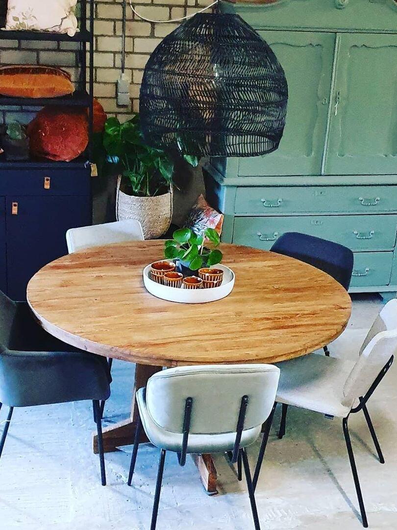 Black woven lamp above a small round table