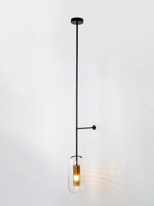 Long black fixture with a round upper canopy, side support and illuminated clear glass capsule